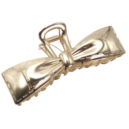 Gold bow-shaped hair clip on a white background