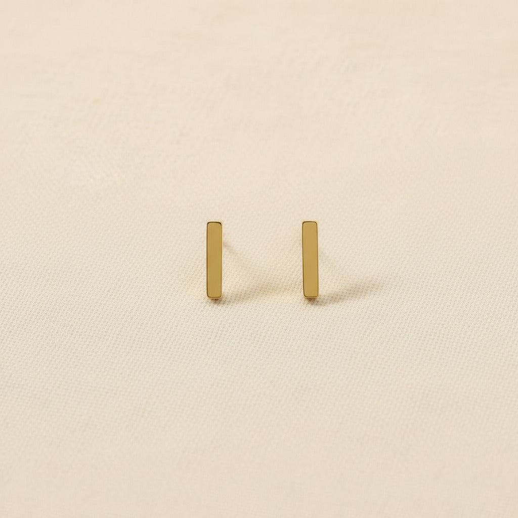 Pair of gold and rhodium plated earrings on neutral background