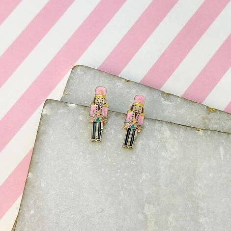 pink nutcracker earrings against a pink and white background