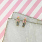 pink nutcracker earrings against a pink and white background