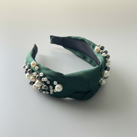 Green headband with pearls on a white background