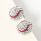 Baseball-shaped earrings with red and clear gemstones on a white surface