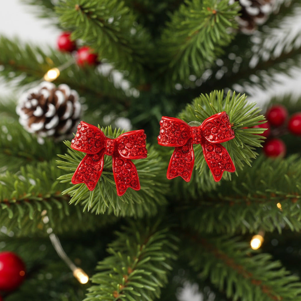 Red bow-shaped earrings on a christmas tree