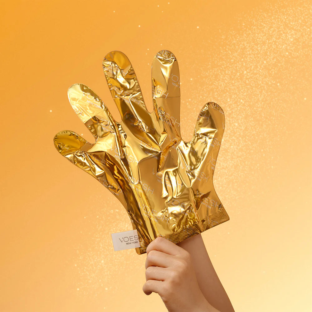 Gold foil glove held by a hand against a gold background