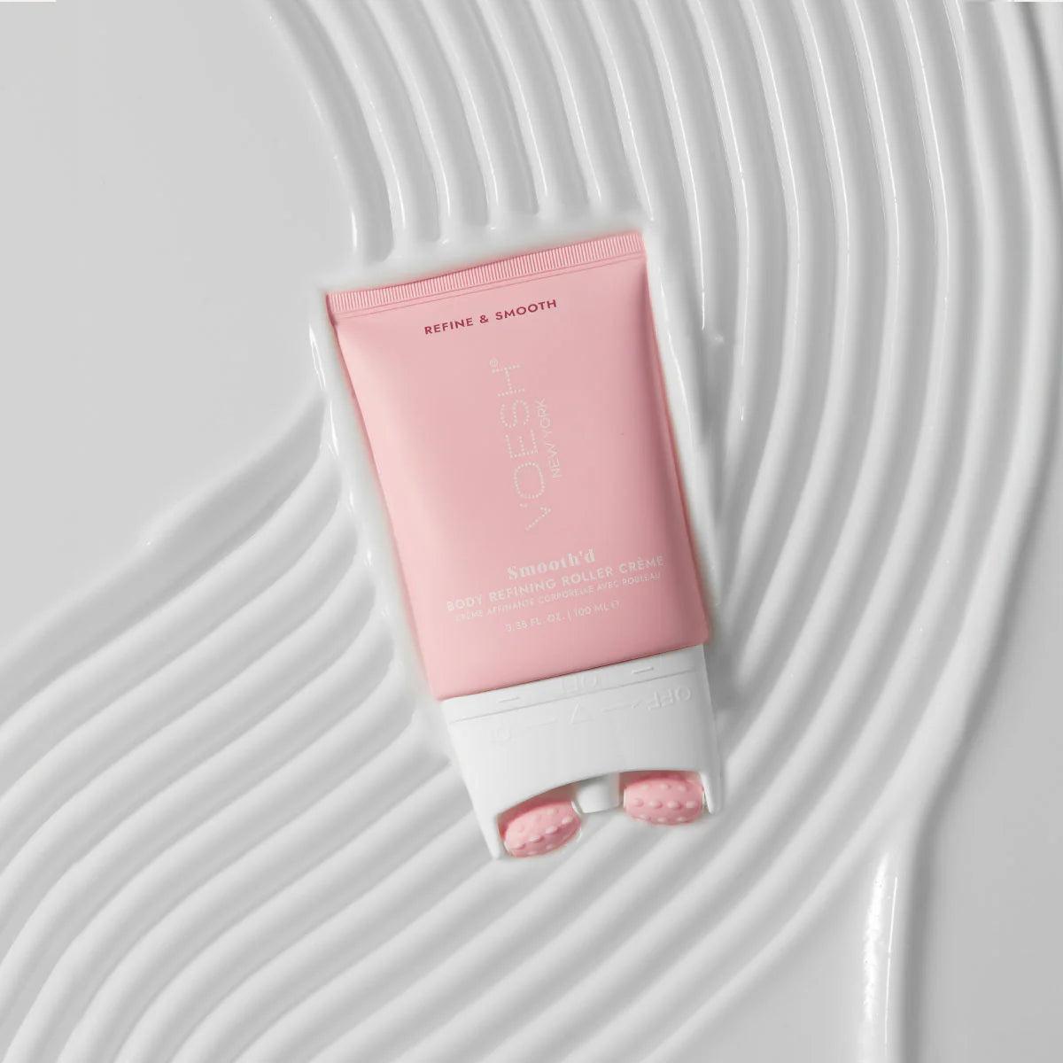 Pink skincare product on a textured white background